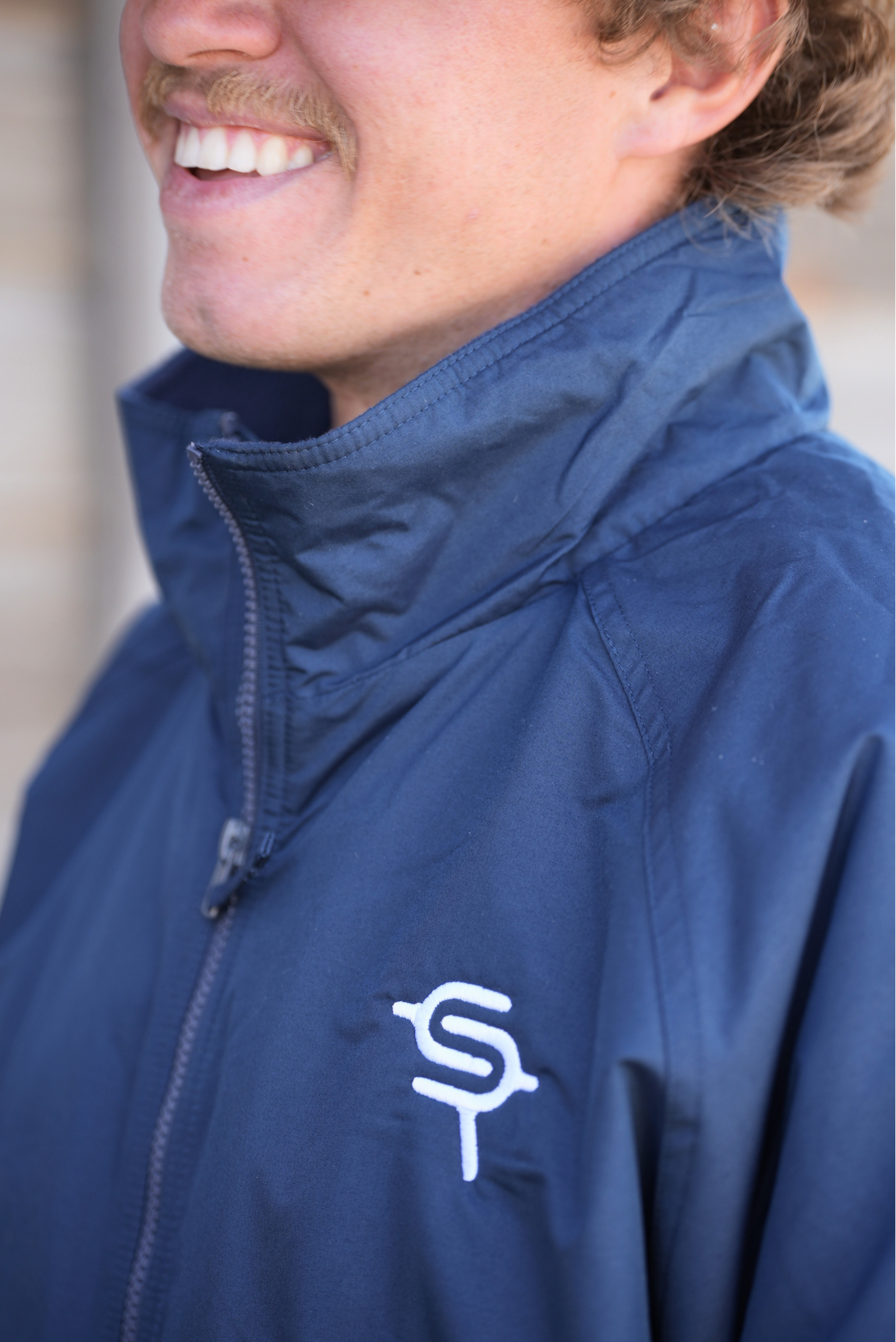 Navy blue jacket with a logo on a blurred background